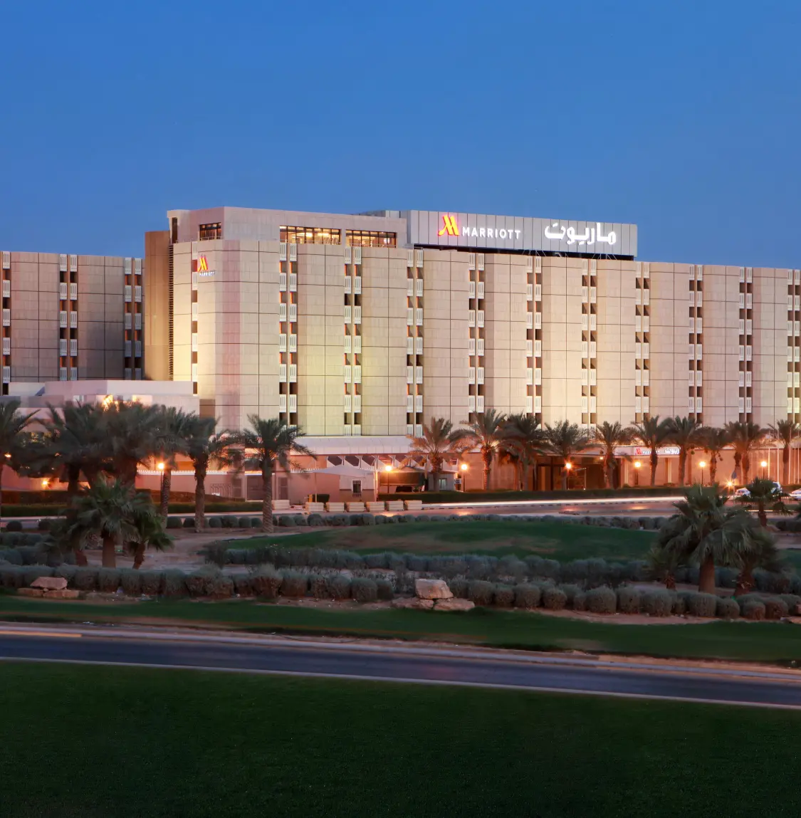 Duży hotel z basenem i palmami